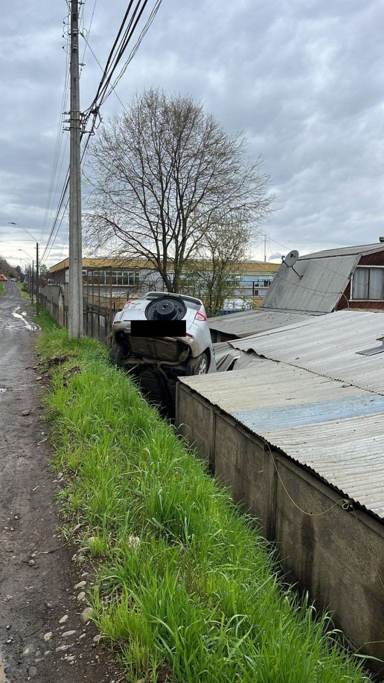 Conductor escapa tras caer con su auto sobre una casa
